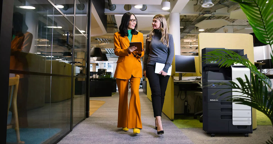 Two women walking forward in office