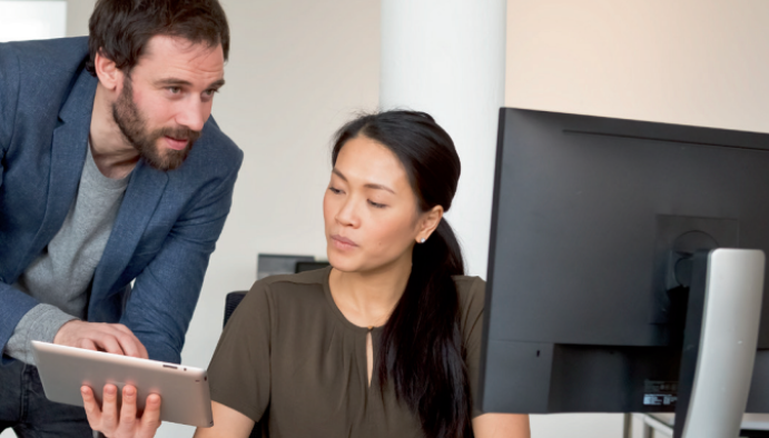 A man shows his coworker something on his tablet.